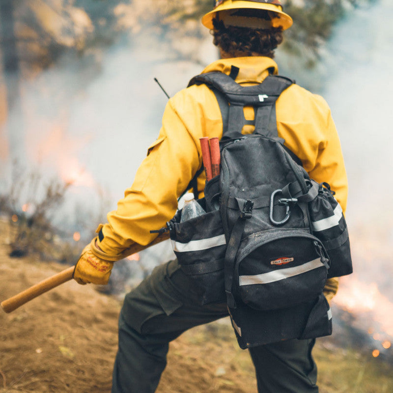 Firefighter wearing True North Bushwhacker pack near a prescribed fire