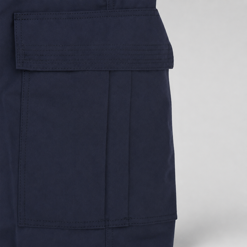 Close-up of a dark navy blue garment showing a large front flap pocket with precise stitching on a light gray background.