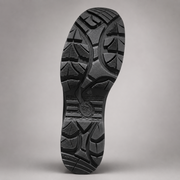 A close-up studio shot of the textured black rubber outsole of a shoe, showing the tread pattern against a neutral gray background.
