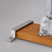 Metal retaining bracket mounted beside a Hebert hose clamp on a wooden base