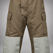Close-up of khaki INNOTEX RDG20 turnout pants showing flap-covered side pockets and gray knee reinforcements.