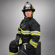 Firefighter wearing a black INNOTEX RDG50 turnout coat with lime-yellow and silver reflective trim.