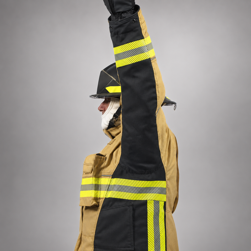 Side view of a firefighter raising one arm in the RDG60 coat, showing the black underarm panel and reflective trim.