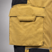 Close-up of a gold RDG60 pants bellows pocket with flap, pull tab, and stitched edges.