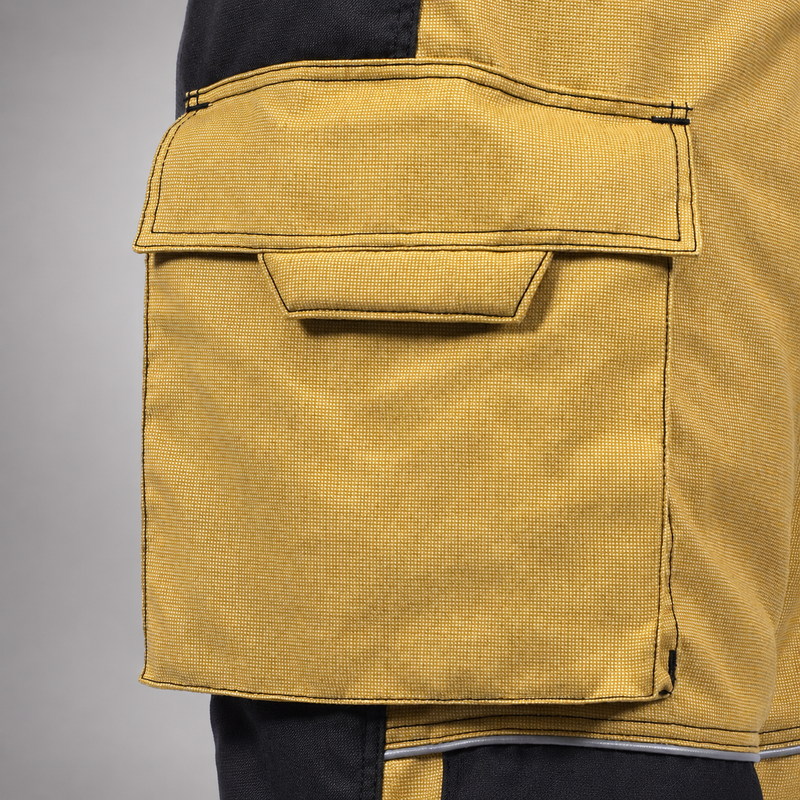 Close-up of a gold RDG60 pants bellows pocket with flap, pull tab, and stitched edges.