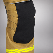 Close-up of the RDG60 pants showing a shaped black knee panel bordered by gold fabric and reflective trim below.