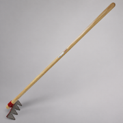 Mower blade rake with a long wooden handle and four triangular steel cutting teeth