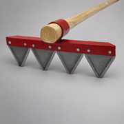 Close-up of four triangular steel teeth riveted to the mower blade rake’s red head.