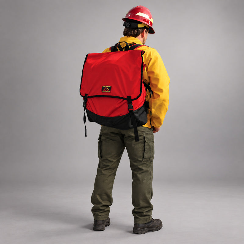 Firefighter wearing the red Strike Team Cascade Hose Pack with black ballistic nylon base and quick-release buckles.