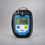 Dräger Pac 6000 O2 single-gas detector on a warm gray studio background