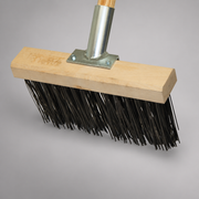 Close-up of the fire broom’s flat steel bristles, wooden head block and steel handle shank.