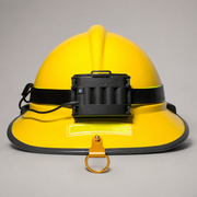 A yellow firefighter hard hat with a black headlamp mounted on the front, a black adjustable strap, and a gold-colored hanging ring, shown against a neutral gray background.