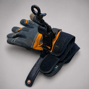 A pair of dark gray and orange work gloves with a black metal swivel hook and wrist strap attached, photographed on a neutral light gray background.