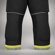 Close-up of black INNOTEX RDG50 turnout pants showing knee panels and segmented reflective trim at the cuffs.
