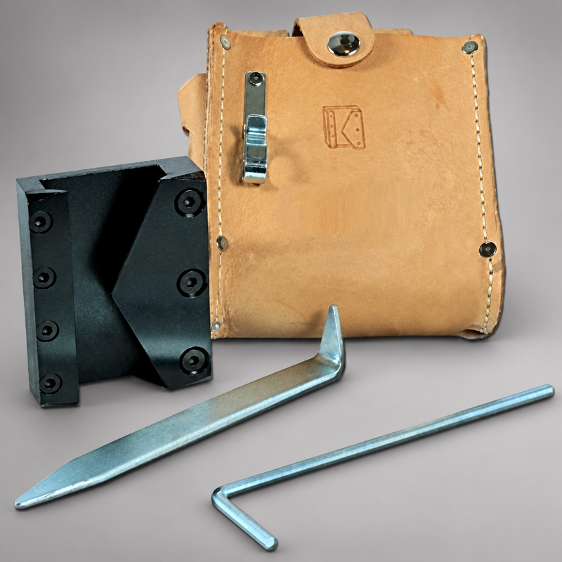 A leather tool pouch with a metal clasp, shown with two steel tools and a black metal bracket on a neutral gray studio background. The pouch has a tan leather finish with visible stitching and a stamped logo.