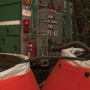 PVC suction hose connected to a USDA Forest Service fire engine during portable-tank drafting