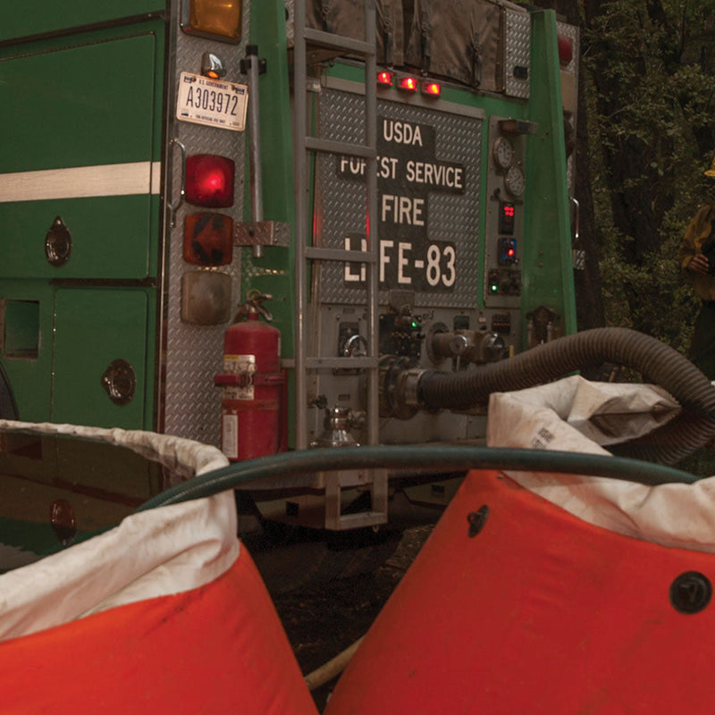 PVC suction hose connected to a USDA Forest Service fire engine during portable-tank drafting