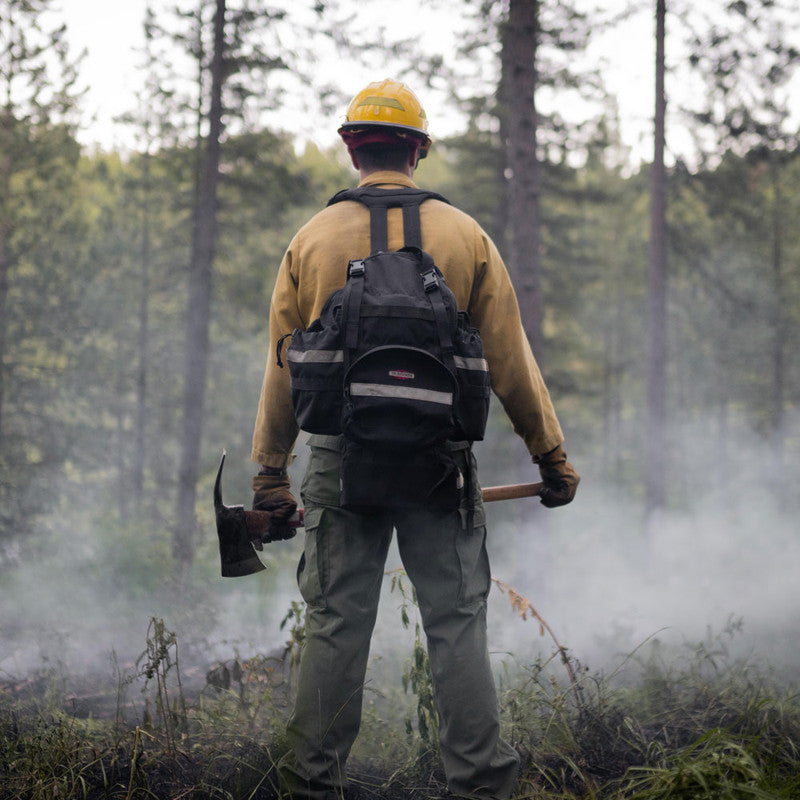 Wildland firefighter wearing a True North Bushwhacker pack in smoky condition
