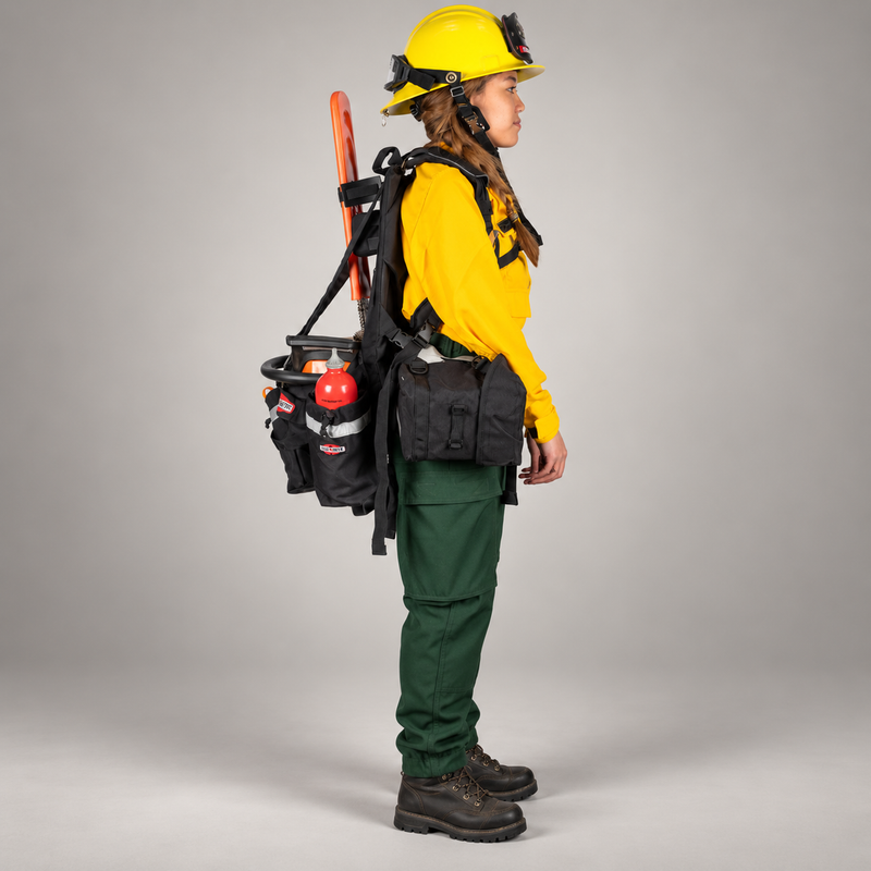 Side view of a wildland firefighter wearing a True North Chainsaw Pack with chainsaw and side storage pouches