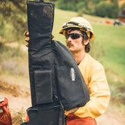 Firefighter carrying a chainsaw with a True North saw bar cover