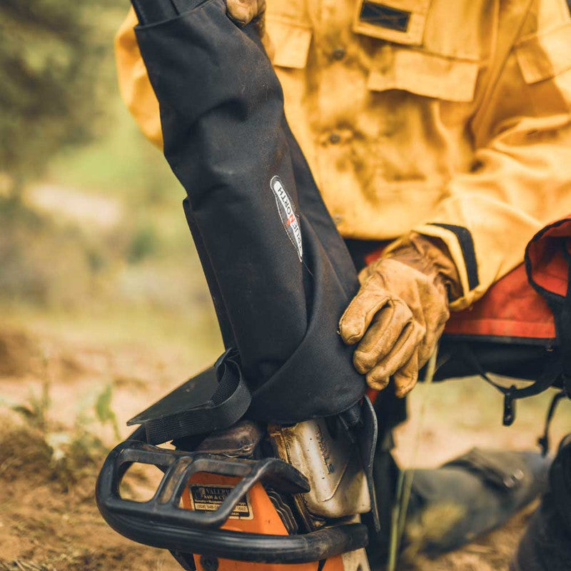 Firefighter handling the True North saw bar cover near the chainsaw body and leather guard