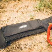 True North saw bar cover lying beside a chainsaw on the ground