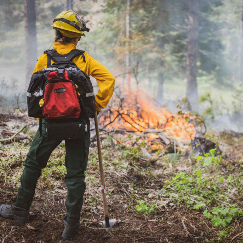 Firefighter wearing a red True North Spitfire pack during wildland operations