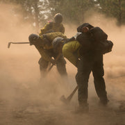 Wildland firefighters using hand tools during fireline construction in dry vegetation
