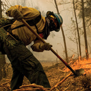 Wildland firefighter using a Combi Tool during fireline construction