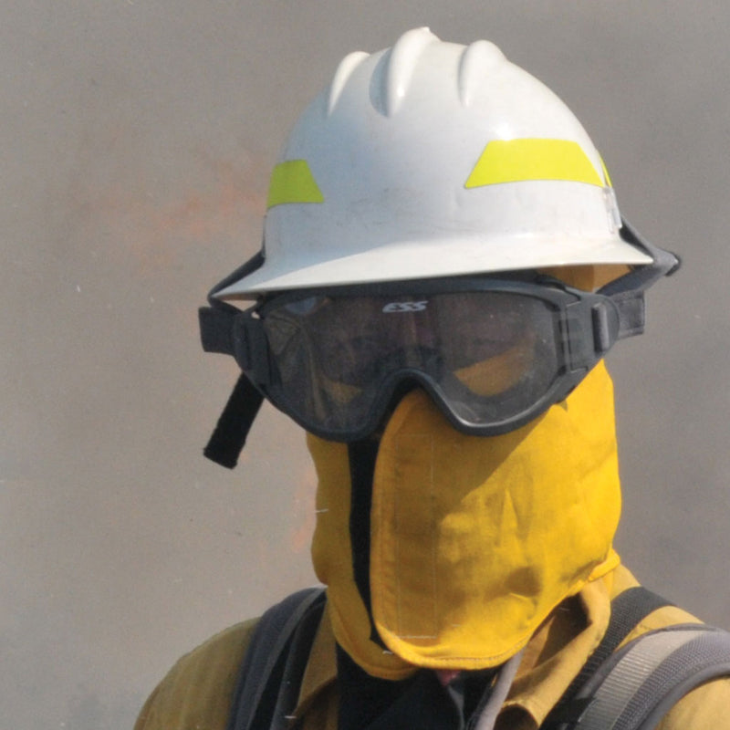 Wildland firefighter wearing ESS Striketeam XTO protective goggles with a white wildland fire helmet and neck shroud