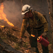 Wildland firefighter carrying a Cascade drip torch