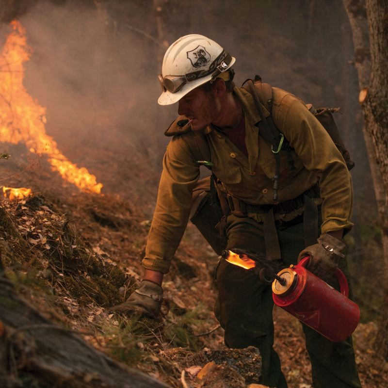 Wildland firefighter carrying a Cascade drip torch