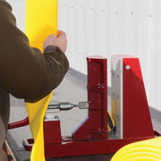 Operator positioning yellow fire hose in an open Cascade fire hose cutter