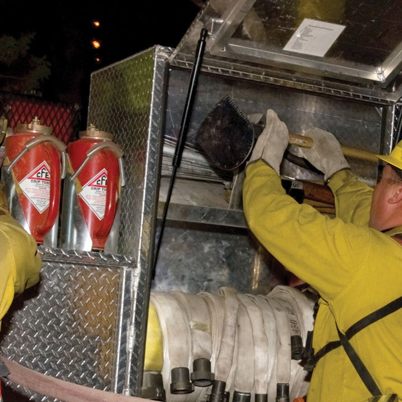 Drip torches stored in brackets inside a fire apparatus compartment