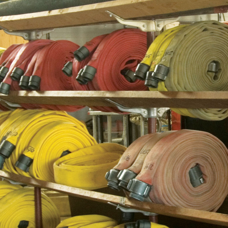 Aluminum hose rack brackets supporting wooden stringers and rolled fire hose