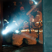 Firefighter using a Streamlight Fire Vulcan LED lantern in a smoky interior