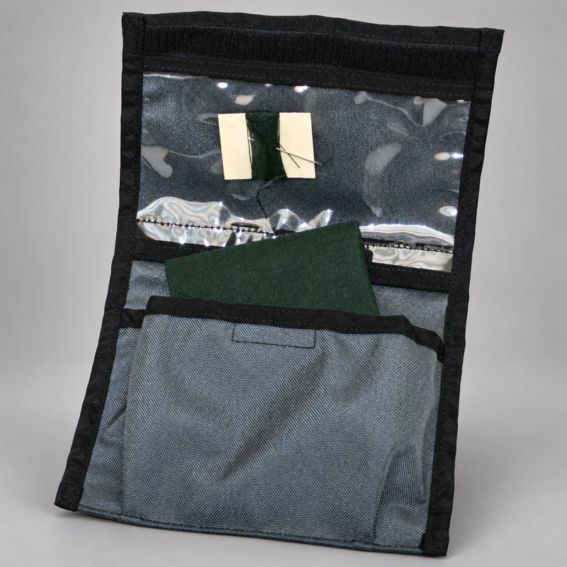 Open Strike Team clothing repair kit Cordura pouch showing green fabric, thread, and sewing needle
